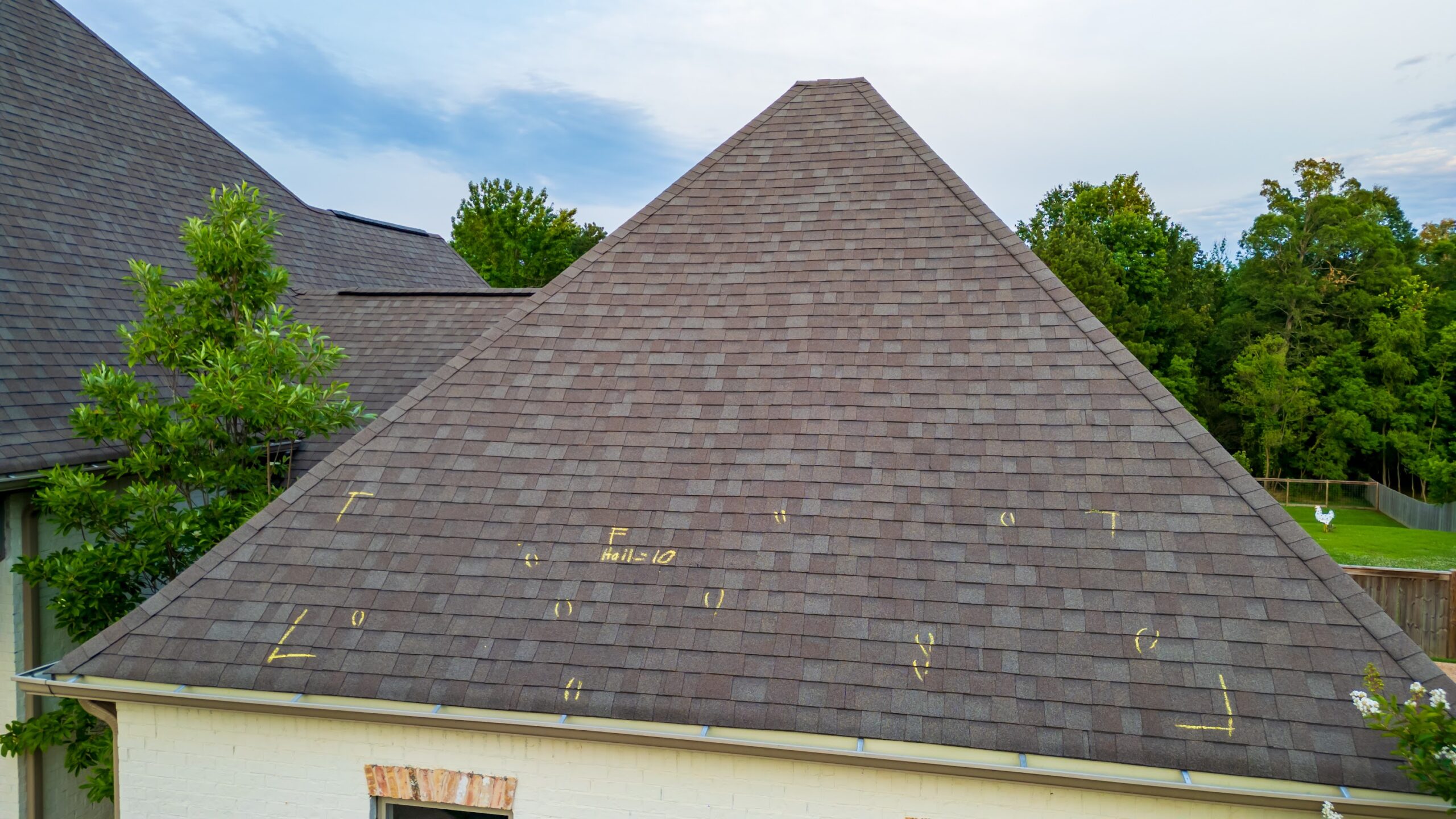 Roof with hail damage and marking from hail insurance inspection